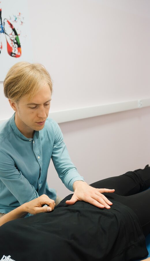 Osteopath Mateusz Stawarz working with a patient